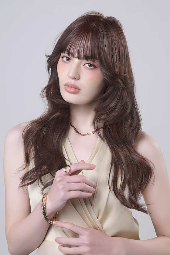 やわらかいオレンジ系でカラーしたロングヘアの女性