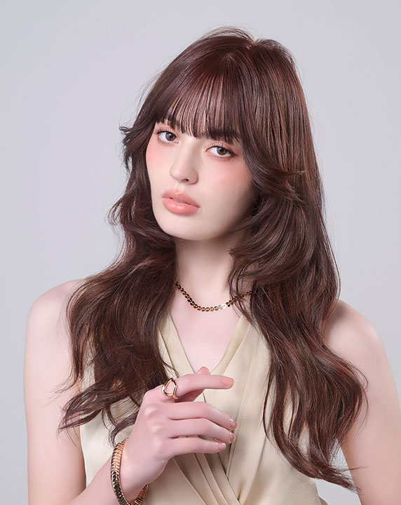 やわらかいオレンジ系でカラーしたロングヘアの女性